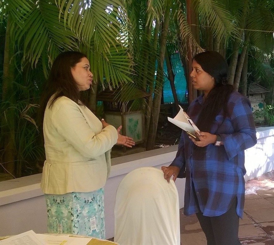 Two women in conversation among palm trees